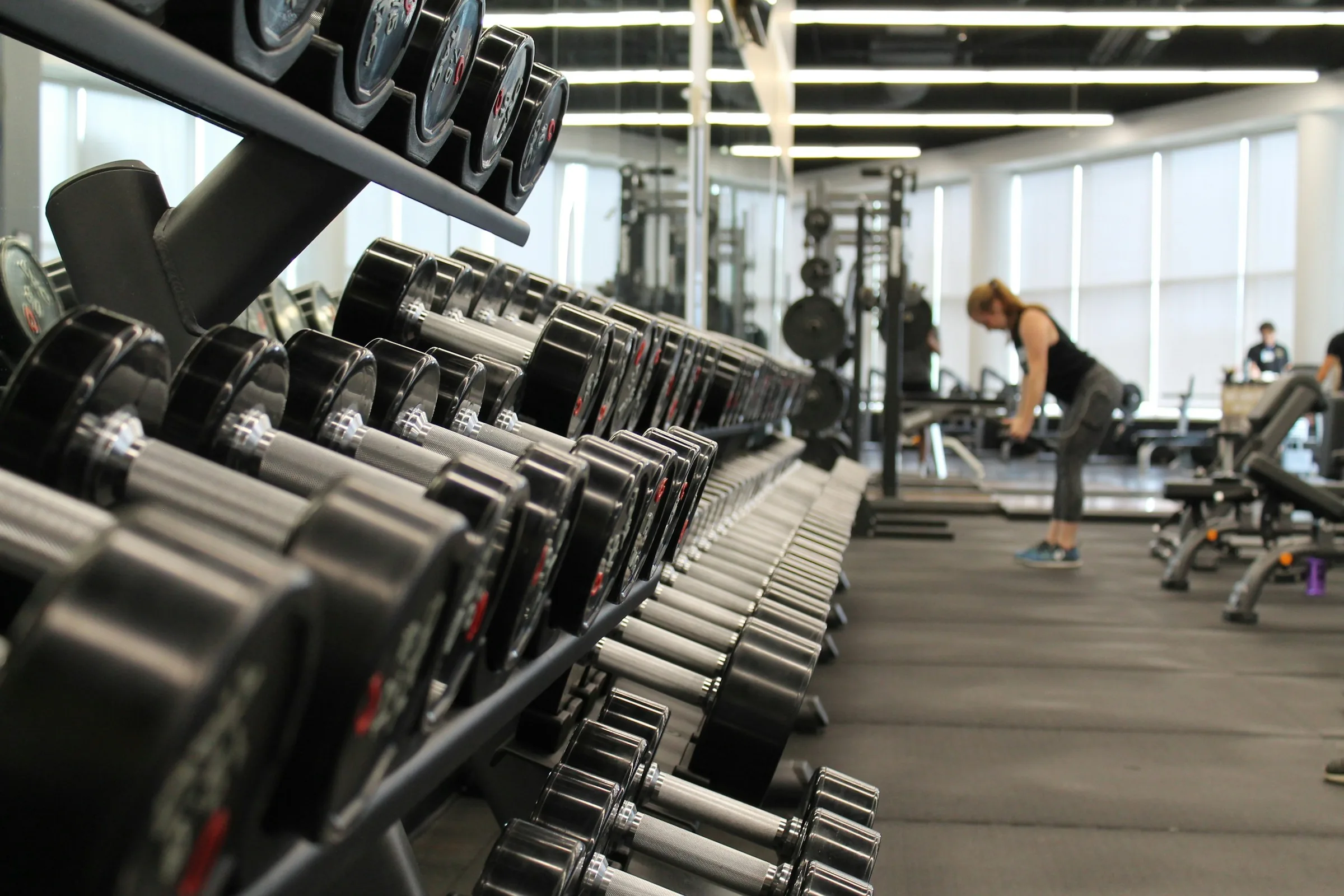 A long rack of dumbbells on the gym floor