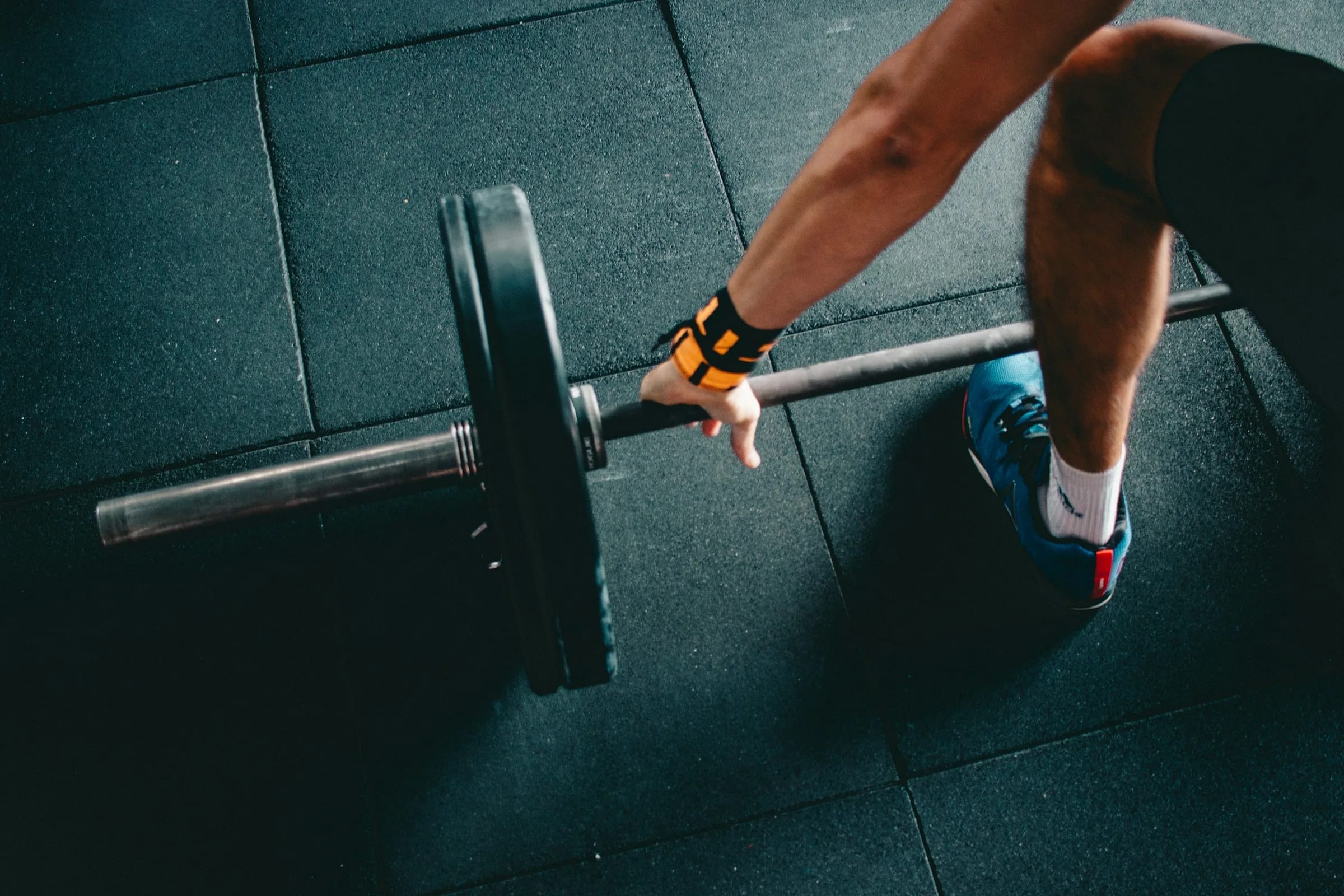 Hands loading a weight plate onto a barbell